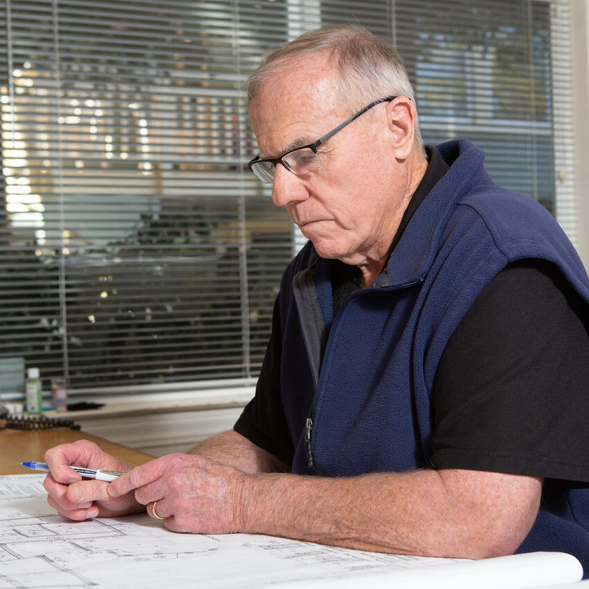 Brian Gannon – Founder + Project Manager, Gannon Construction Company at his desk with plans
